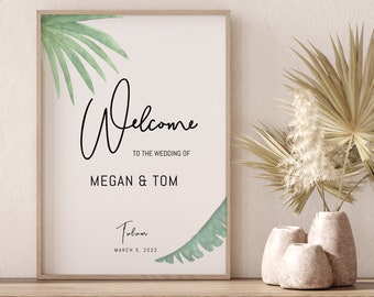 May include: A framed welcome sign with a tropical theme. The sign says "Welcome to the wedding of Megan & Tom Tulum March 5, 2022".