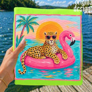 May include: A vibrant, neon green beach towel featuring a colorful illustration of a leopard wearing sunglasses, lounging on a pink flamingo float in the ocean. The background includes a sunset, palm tree, and the text "original designer".