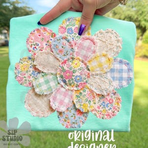 Comfort Colors Mockup. May include: A light turquoise t-shirt featuring a large, appliqued flower design. The flower is composed of various fabric scraps in floral and gingham patterns, with a frayed edge. The text "original designer" is visible.