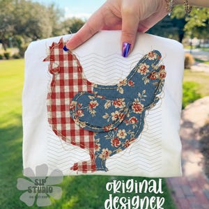 May include: White t-shirt featuring a patchwork chicken design. The chicken's head is red and white checkered, while the body is blue floral. The shirt has the text "SIP STUDIO DO NOT COPY" and "original designer".