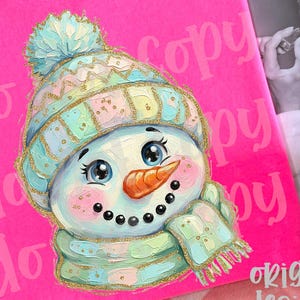 May include: A bright neon pink t-shirt featuring a graphic illustration of a snowman wearing a pastel-colored knit hat and scarf with gold glitter accents. The snowman has a carrot nose, black button eyes, and a smiling mouth.