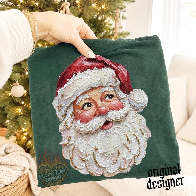 Puede incluir: Una sudadera verde oscuro con un gr&aacute;fico de estilo pintura al &oacute;leo texturizada que representa a Santa Claus. El dise&ntilde;o muestra a un Santa sonriente con un gorro rojo y una espesa barba blanca, realizado con pinceladas visibles y marcadas.