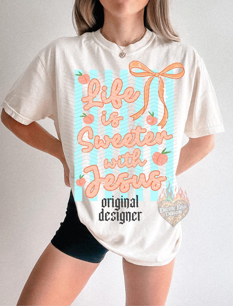 May include: Cream-colored t-shirt with the phrase "Life is Sweeter with Jesus" in peach-colored script. The design includes peach illustrations and a peach-colored bow. The words "original designer" are printed below the main text.