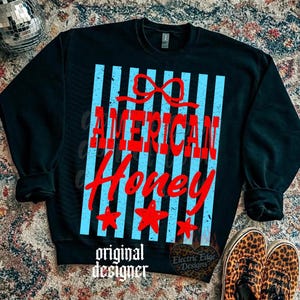 May include: Black sweatshirt with the words "AMERICAN Honey" in red, set against a backdrop of light blue vertical stripes. The design includes a red bow and three red stars. The words "original designer" are at the bottom.