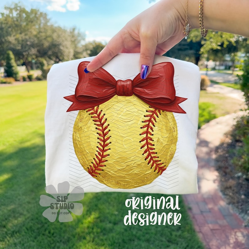 Pu&ograve; includere: T-shirt bianca con un disegno di softball e un fiocco rosso. La palla da softball &egrave; gialla con cuciture rosse. Il testo "original designer" &egrave; visibile in basso a destra. Il testo "SIP STUDIO DO NOT COPY" &egrave; visibile in basso a sinistra.