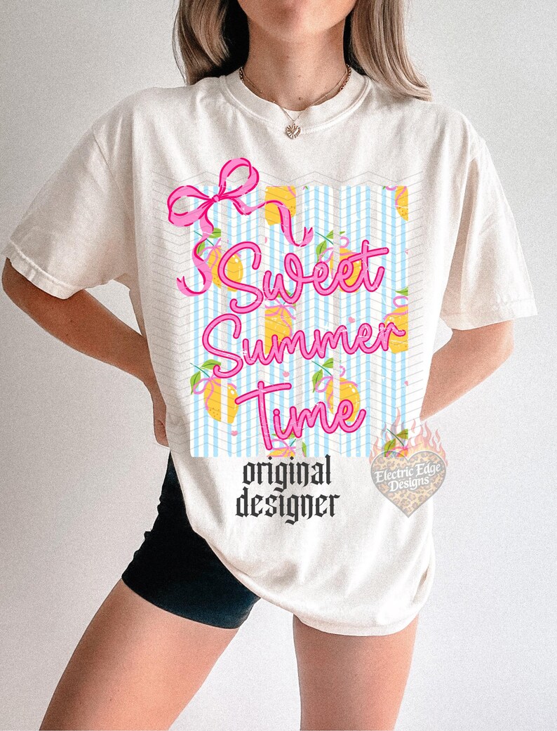 May include: Cream-colored t-shirt with a graphic that says "Sweet Summer Time" in pink script. The design includes a pink bow, lemons, and a blue and white checkered pattern. The words "original designer" are printed below.