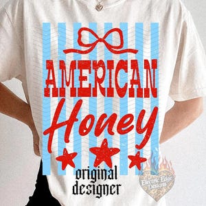 May include: Cream-colored t-shirt with a patriotic design. The design features the words "AMERICAN Honey" in red, with a red bow, blue and white stripes, and three red stars. The words "original designer" are below the text.