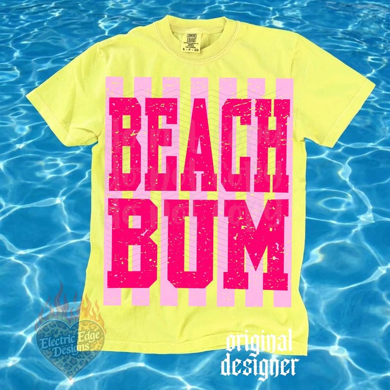 May include: Yellow t-shirt with the words "BEACH BUM" in large, pink, block letters. The text is set against a background of pink and yellow vertical stripes. The shirt has a crew neck and short sleeves.