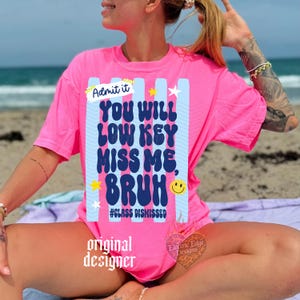 May include: A bright pink t-shirt with the text "Admit it, You Will Low Key Miss Me, Bruh" in a playful font. The design includes blue stripes, stars, and a smiley face. The phrase "#Class Dismissed" is also present.
