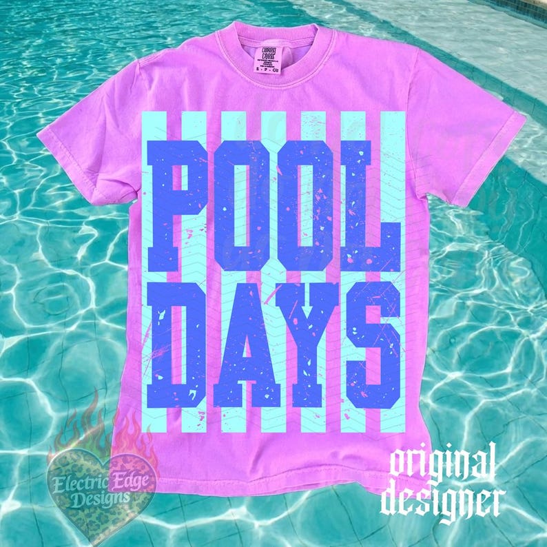 May include: A lilac t-shirt featuring the text "POOL DAYS" in blue block letters, set against light blue vertical stripes. The shirt has a crew neck and short sleeves. The words "Electric Edge Designs" and "original designer" are also visible.