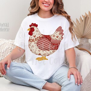 May include: White t-shirt with a large chicken design. The chicken is made up of red, white, and beige fabric patterns, with a red comb and yellow feet. The words "original designer" are visible on the shirt.