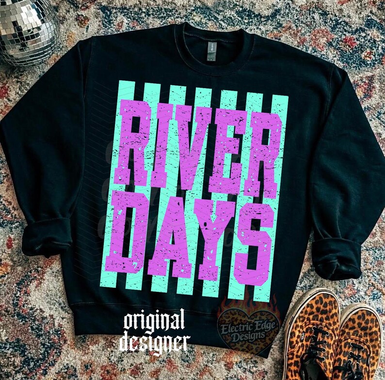 May include: Black sweatshirt with the words "RIVER DAYS" in distressed purple letters over a light blue striped background. The words "original designer" are printed at the bottom. Leopard print shoes are visible.