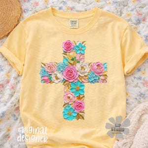 May include: Yellow t-shirt featuring a floral cross design. The cross is adorned with pink, white, and turquoise flowers. The shirt has the text "original designer" and "SIP STUDIO DO NOT COPY".