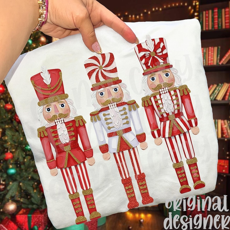 May include: A white pillowcase featuring three festive nutcracker illustrations. Each nutcracker is dressed in red and white uniforms with gold accents. The design includes the text "original designer".