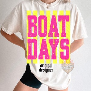 Może przedstawiać: Kremowy t-shirt z napisem "BOAT DAYS" w wytartych r&oacute;żowych literach na ż&oacute;łtym tle w paski. Poniżej napis "original designer" czcionką. Logo w kształcie serca znajduje się w prawym dolnym rogu.