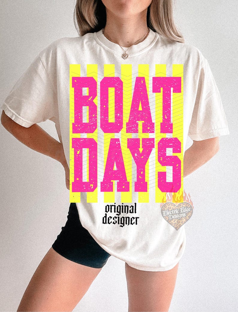 Może przedstawiać: Kremowy t-shirt z napisem "BOAT DAYS" w wytartych r&oacute;żowych literach na ż&oacute;łtym tle w paski. Poniżej napis "original designer" czcionką. Logo w kształcie serca znajduje się w prawym dolnym rogu.
