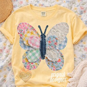 May include: A yellow Comfort Colors t-shirt featuring a patchwork butterfly design. The butterfly has wings made of various floral and patterned fabrics, with a denim body. The text "original designer" is printed on the shirt.