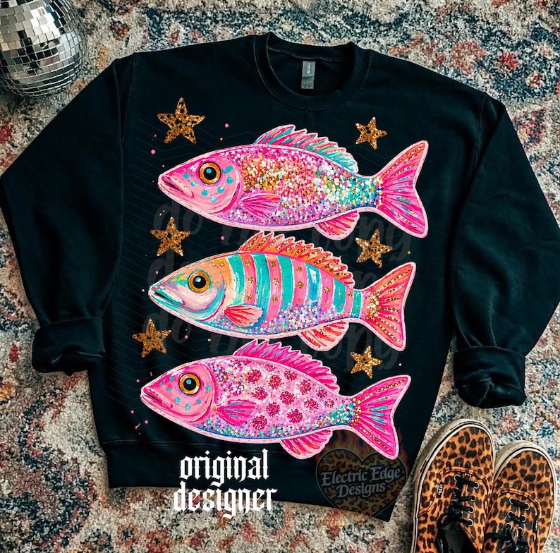 Puede incluir: Sudadera negra con tres dise&ntilde;os de peces coloridos con detalles brillantes y estrellas. Los peces son rosas, naranjas y azules. El texto "original designer" est&aacute; impreso en la parte inferior.