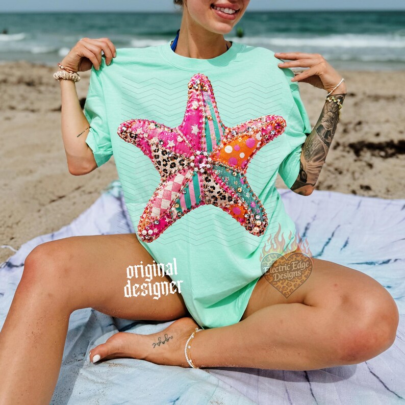 May include: A light green t-shirt featuring a large, colorful starfish design. The starfish is made of various patterned fabrics, including pink, orange, and leopard print. The shirt has the words "original designer" printed on it.