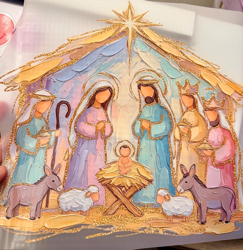 May include: A nativity scene illustration featuring a central star, Mary, Joseph, the infant Jesus in a manger, and three figures, accented with gold glitter outlines. The figures are rendered in pastel blue, pink, and yellow tones with thick paint strokes.