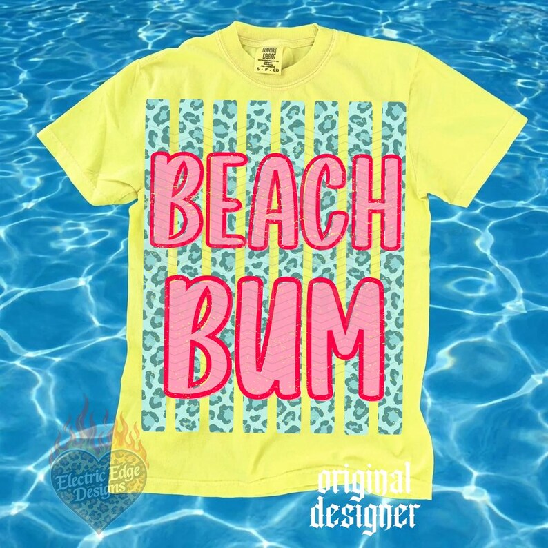 May include: Yellow t-shirt with the words "BEACH BUM" in pink, outlined in red. The text is set against a background of vertical stripes with a teal leopard print. The shirt has short sleeves and a crew neck.