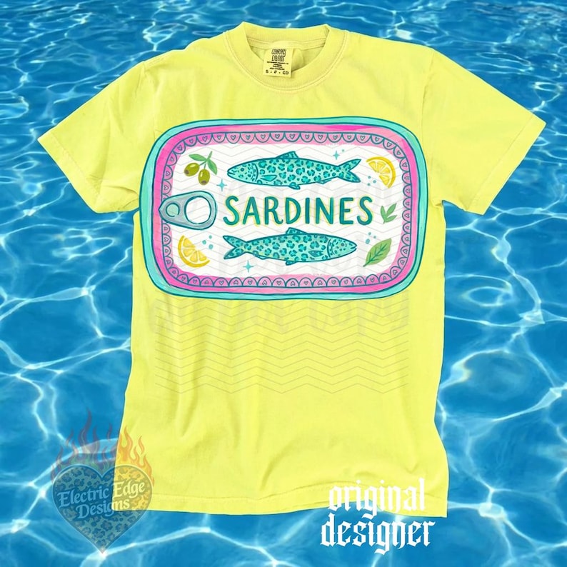 May include: A yellow t-shirt with a graphic of a sardine can. The can design features two turquoise fish with leopard print patterns, olives, lemon slices, and the word "SARDINES". The shirt has the text "original designer" at the bottom.