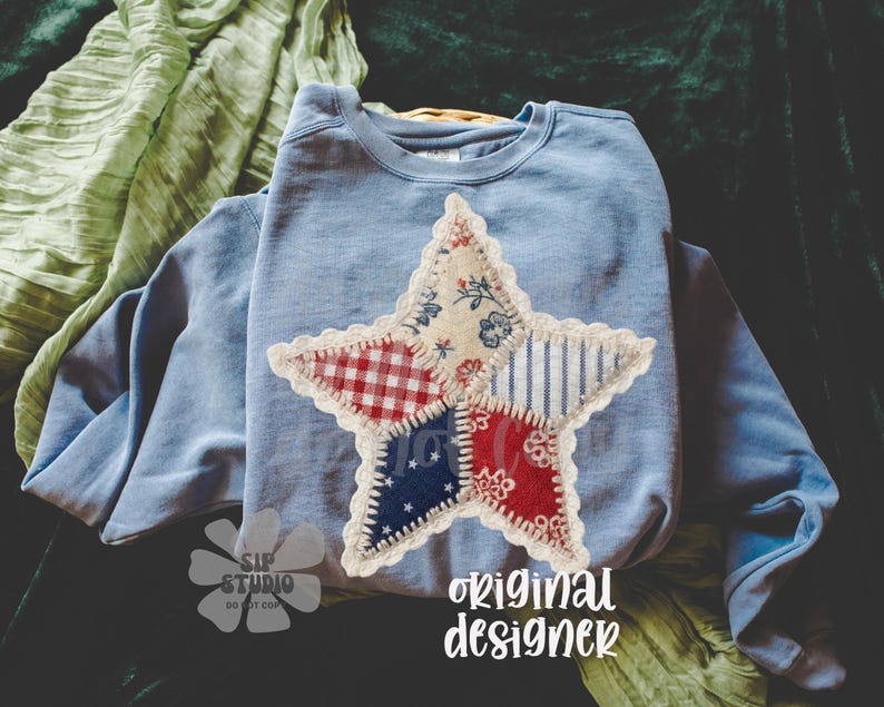 May include: A light blue sweatshirt with a large star applique. The star is made of various patterned fabrics in red, white, and blue, with a lace trim. The text "original designer" is visible.