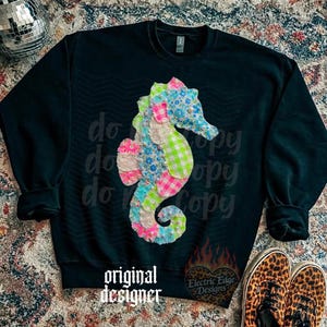 May include: Black sweatshirt featuring a colorful seahorse design made of floral, gingham, and solid fabric patches. The words "original designer" are printed at the bottom. The design includes the text "do copy" repeated diagonally.
