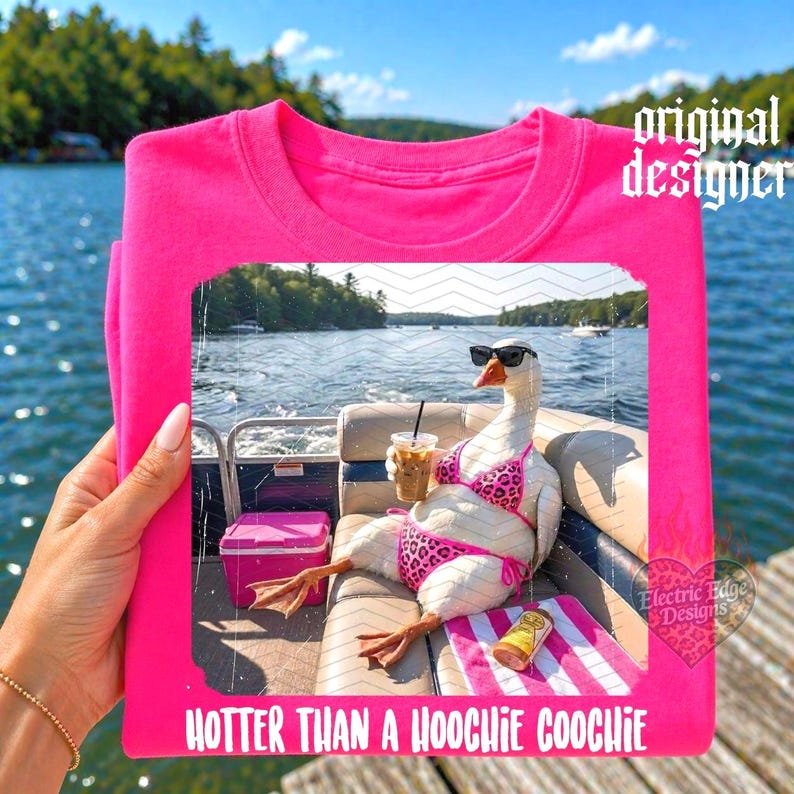 Puede incluir: Camiseta rosa brillante con un dise&ntilde;o humor&iacute;stico. Muestra un ganso con gafas de sol y bikini, relaj&aacute;ndose en un barco con una bebida. El texto "HOTTER THAN A HOOCHIE COOCHIE" est&aacute; en la parte inferior.