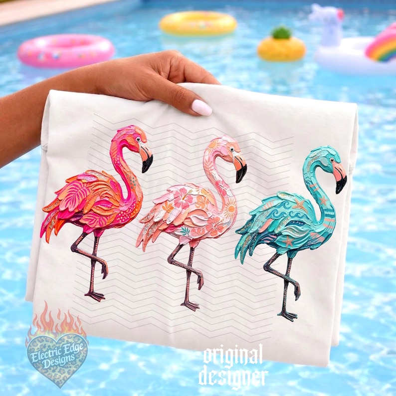 May include: A white tote bag featuring three colorful flamingo designs. The flamingos are in shades of pink, orange, and teal, with intricate details. The bag is held up against a pool background with floating pool toys. The text "Electric Edge Designs" and "original designer" are visible.