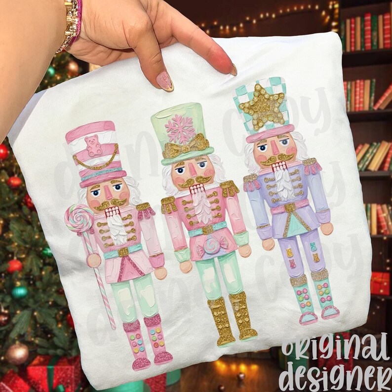 May include: White pillowcase featuring three colorful nutcracker illustrations. Each nutcracker is dressed in pastel pink, mint green, and lavender, with gold accents. One holds a lollipop, and all have detailed uniforms.