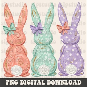 May include: Three decorative Easter bunny figurines in pastel colors: coral, mint green, and lavender. Each bunny has a bow, a white rose tail, and gold glitter accents. The image includes the text "PNG DIGITAL DOWNLOAD".