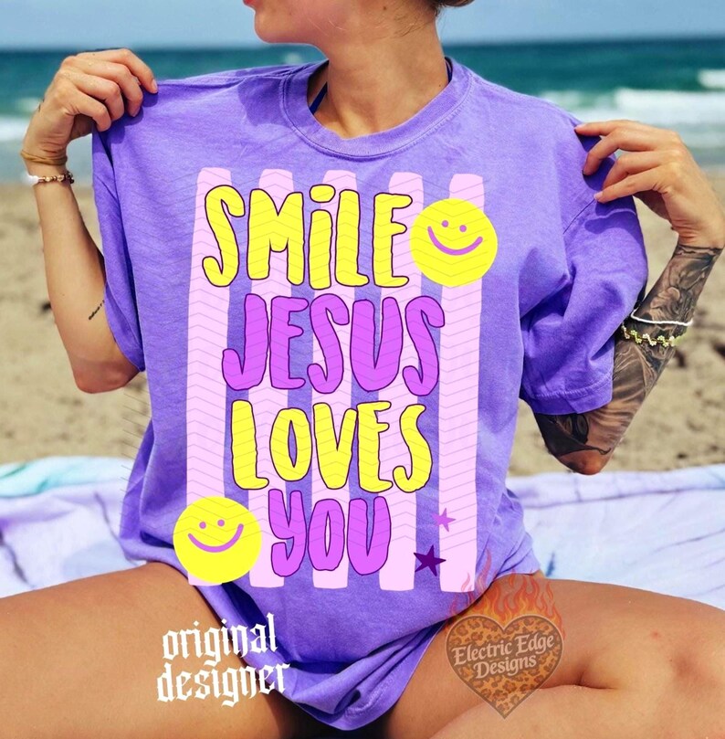 May include: A purple t-shirt with the text "SMILE JESUS LOVES YOU" in yellow and pink. The design includes smiley faces and stars. The shirt is a short-sleeved, casual style.