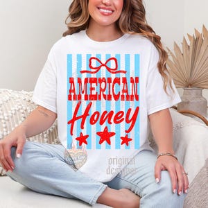May include: White t-shirt with the text "AMERICAN Honey" in red, with a bow and three red stars. The shirt has a blue and white striped background.