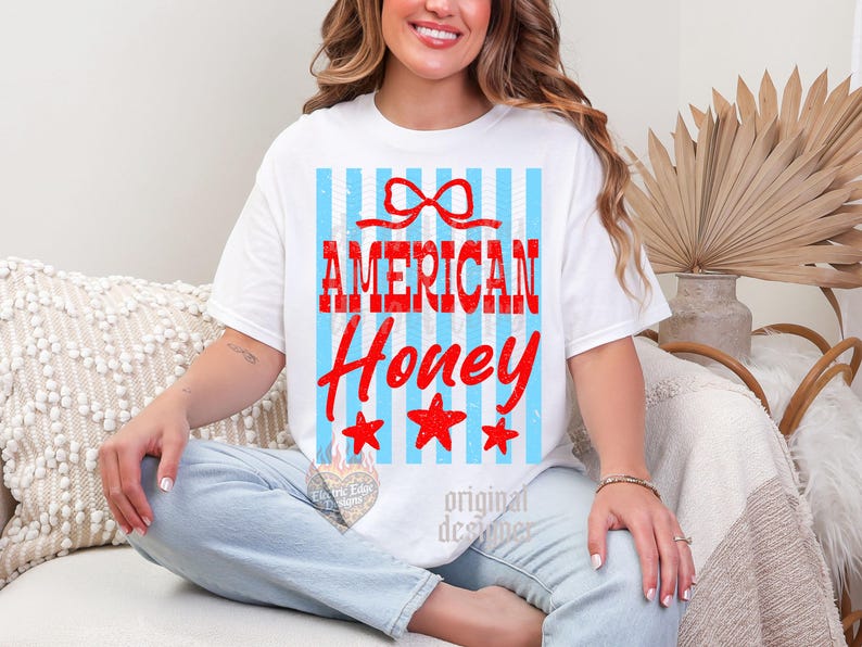 May include: White t-shirt with the text "AMERICAN Honey" in red, with a bow and three red stars. The shirt has a blue and white striped background.