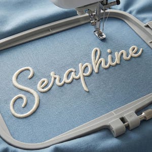 3D puff embroidery font stitched on fabric hoop displaying raised puff texture and cursive design, high quality digital embroidery alphabet files for machine embroidery including BX, PES, DST, EXP, JEF and more, perfect for personalization and unique craft projects.