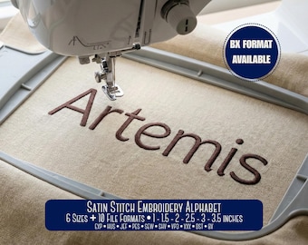 May include: A sewing machine needle positioned over a light beige fabric held in a gray embroidery hoop. The fabric features the embroidered brown text Artemis. A blue circular badge reads BX FORMAT AVAILABLE. Text below reads SATIN STITCH EMBROIDERY ALPHABET 6 SIZES + 10 FILE FORMATS 1 - 1.5 - 2 - 2.5 - 3 - 3.5 INCHES.