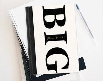 May include: A black and white notebook with the word "BIG" in large, bold, black letters. The word "Idea Book" is written in gold script below the word "BIG".