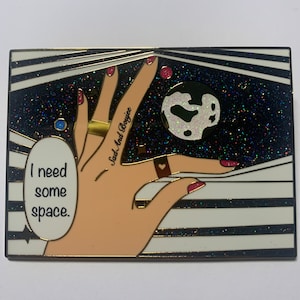 May include: A black and white striped background with a hand reaching up to hold a white and silver glitter moon. The hand has a gold ring on the middle finger and a red heart ring on the index finger. The hand has a tattoo that says "Sad And Boyjee". The text "I need some space." is in the lower left corner of the image.