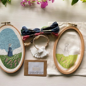May include: An embroidery kit with two oval hoops, one with a completed design and the other with a sketched outline. The kit includes embroidery floss in various colors, needles, and a small card. The finished design depicts a person in a field.