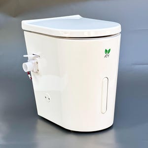 May include: White composting toilet with a green leaf logo that says "ATY".