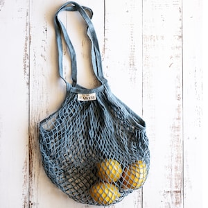 May include: A blue mesh string bag with the word "EARTH" printed on the side. The bag is filled with four yellow lemons.