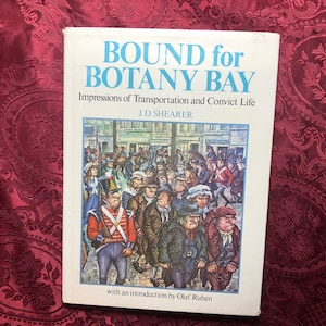 May include: A book cover with the title "BOUND for BOTANY BAY" in large, bold, blue letters. The subtitle is "Impressions of Transportation and Convict Life" in smaller, black letters. The author's name, "J.D. SHEARER", is printed below the subtitle. The cover features a black and white illustration of a group of people walking in a street.