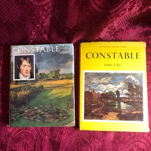 May include: Two hardcover books about the artist John Constable. The book on the left has a portrait of Constable on the cover and the title "Constable and his world" by Reg Gadney. The book on the right has a painting of a river scene and the title "Constable" by Sydney J. Key. The book on the right is part of "The British Painters Series."