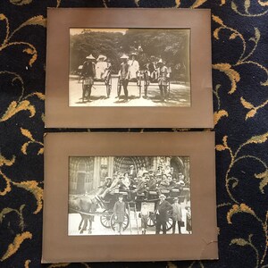 May include: Two black and white photographs in ornate frames. The top photo shows people riding in horse-drawn carriages in a park. The bottom photo shows a group of people standing in front of a building.