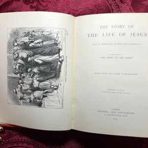 May include: An open book titled "The Story of the Life of Jesus" with a black and white illustration of a group of people. The book is written by the author of "The Story of the Bible" and includes forty full-page illustrations.