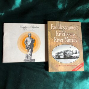 May include: Two books about the history of the Murray River in Australia. The book on the left is titled "Chaffey's Kingdom: The Sunraysia Story" and features a black and white illustration of a man in a suit and hat. The book on the right is titled "Paddlesteamer and Riverboats of the River Murray" and features a colour photograph of a paddle steamer on the river. The book on the right also has the text "Updated Edition" on the bottom right corner.