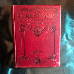 May include: A red hardcover book titled "The Great War: The Standard History of the All-Europe Conflict" with gold lettering and decorative accents. The book is edited by H.W. Wilson.