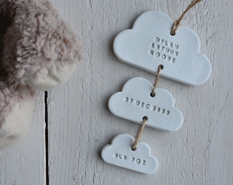 May include: White ceramic cloud ornaments with the text "Dylan Arthur Moore", "27 Dec 2020", and "3lb 7oz" hanging from a string.
