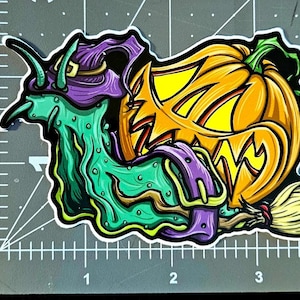 May include: A green and purple cartoon witch riding a broomstick with a jack-o-lantern pumpkin head.